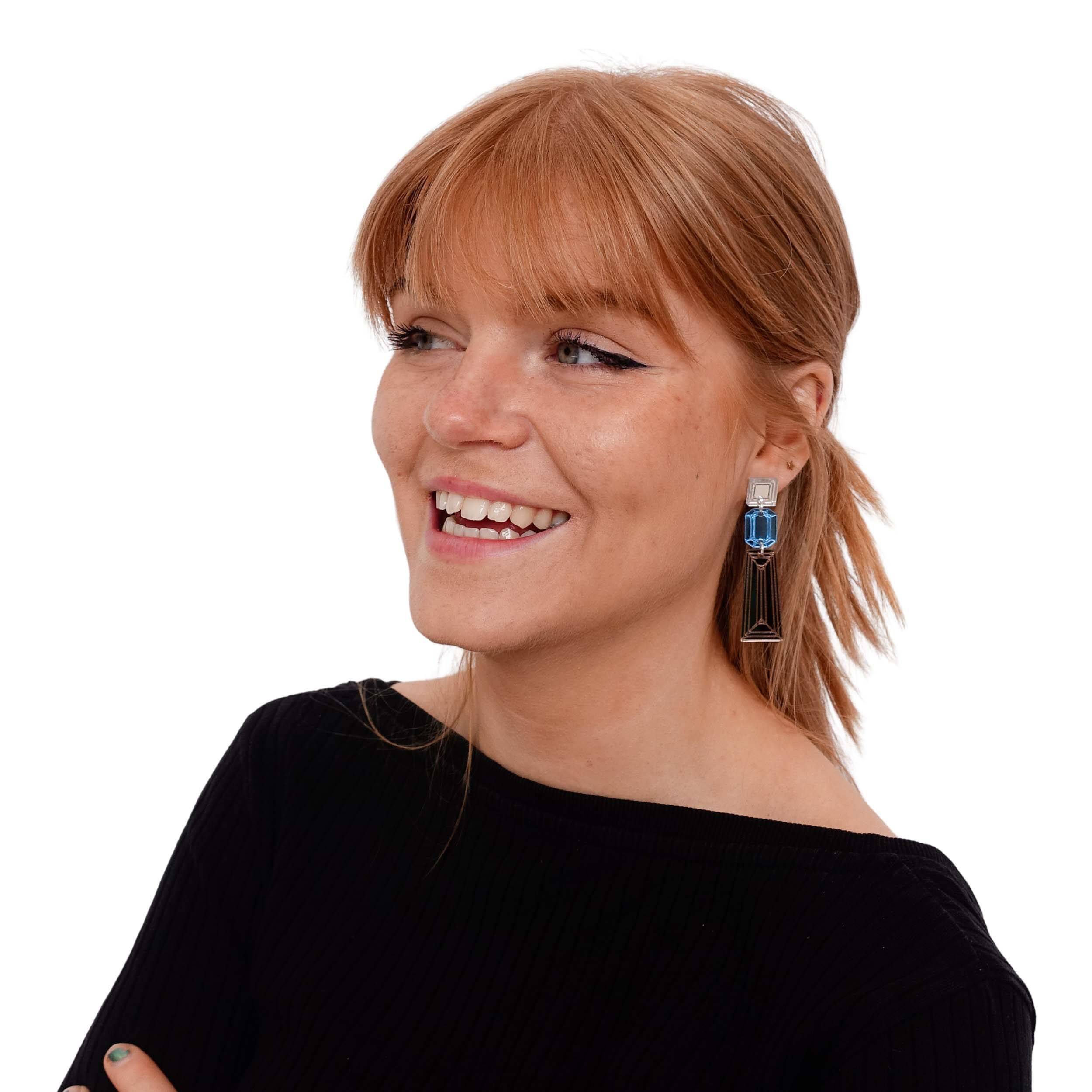 Eliza wears bronze and sky blue Deco Drop earrings, designed by Sarah Day as part of the Austerity Jewels collection for Wear and Resist.