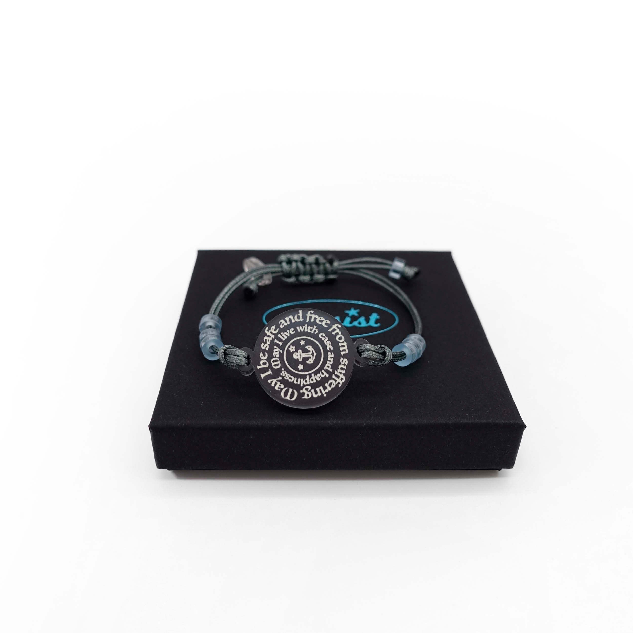 May I Be Safe bracelet in shale shown on a Wear and Resist gift box.