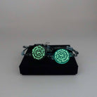 May I Be Safe bracelets in sea foam and shale colours shown glowing in the dark on a Wear and Resist gift box.