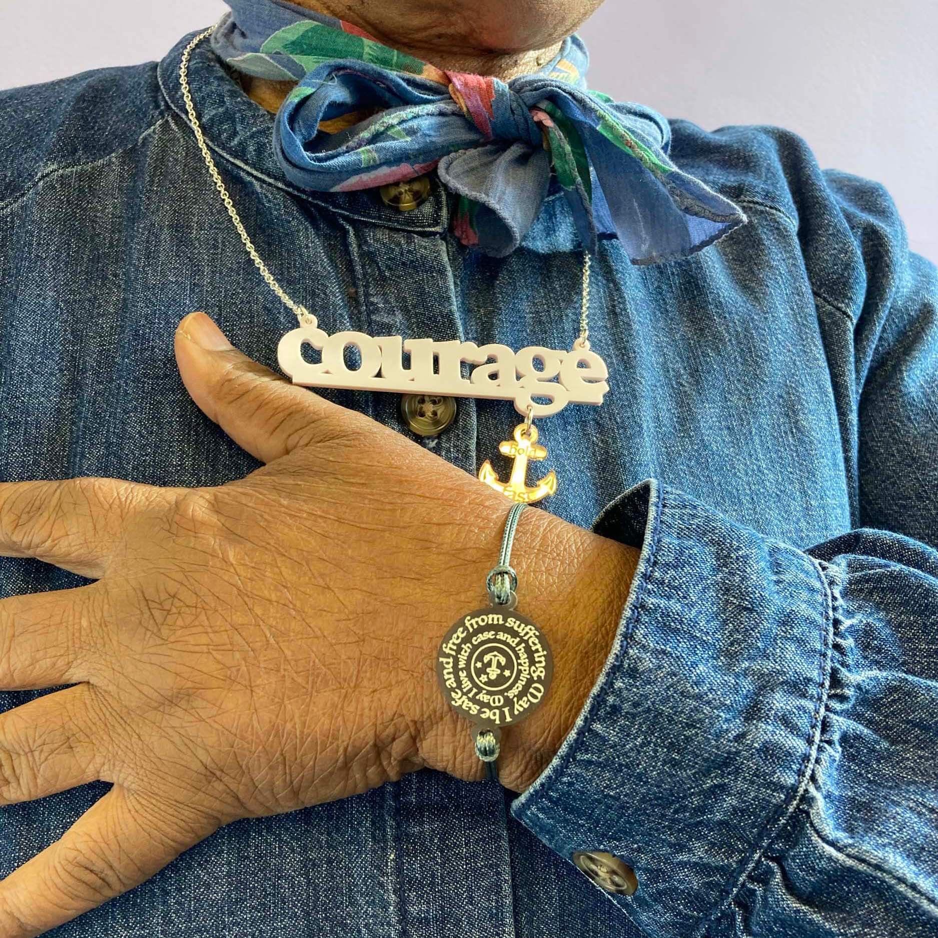 A member of Women for Refugee Women wears a May I Be Safe bracelet in sea foam and a Courage necklace from The Courage Collection, designed by Sarah Day for Wear and Resist. £2 goes to Women for Refugee Women. 