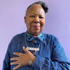 A member of Women for Refugee Women wears a May I Be Safe bracelet in sea foam and a Courage necklace from The Courage Collection, designed by Sarah Day for Wear and Resist. £2 goes to Women for Refugee Women.