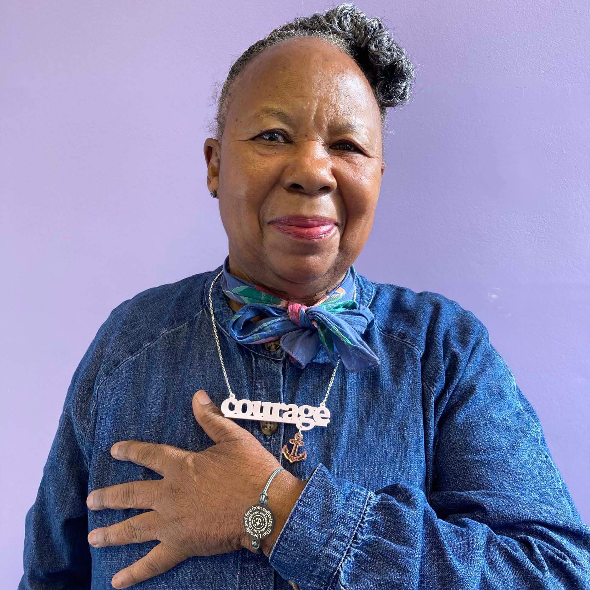 A member of Women for Refugee Women wears a May I Be Safe bracelet in sea foam and a Courage necklace from The Courage Collection, designed by Sarah Day for Wear and Resist. £2 goes to Women for Refugee Women.