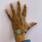 A member of Women for Refugee Women wears a May I Be Safe bracelet in shale from The Courage Collection, designed by Sarah Day for Wear and Resist. £2 goes to Women for Refugee Women.