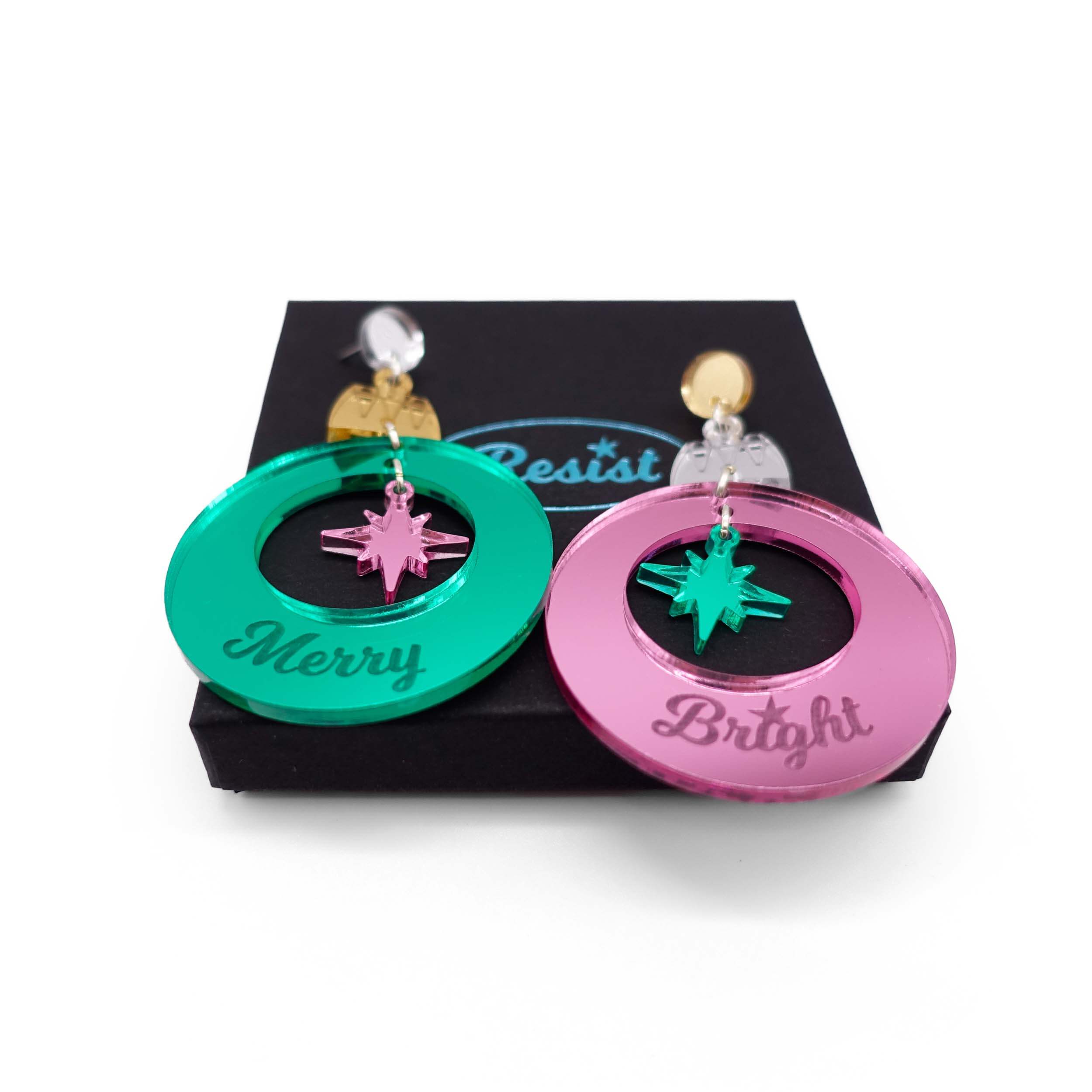 Merry & Bright Christmas bauble earrings in electric green and pink mirror, shown on a Wear and Resist gift box.