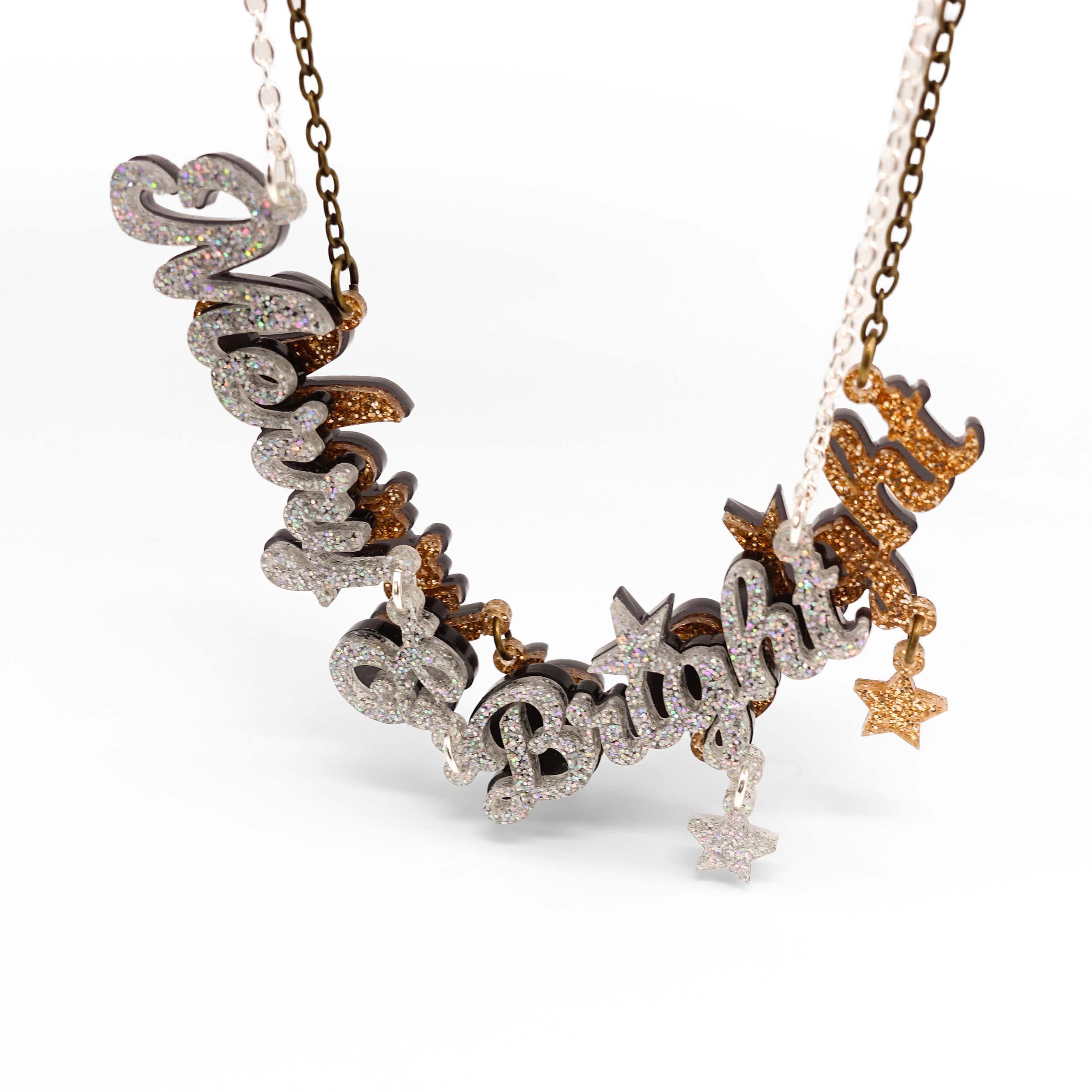 Gold and silver glitter Merry & Bright necklaces shown hanging together.