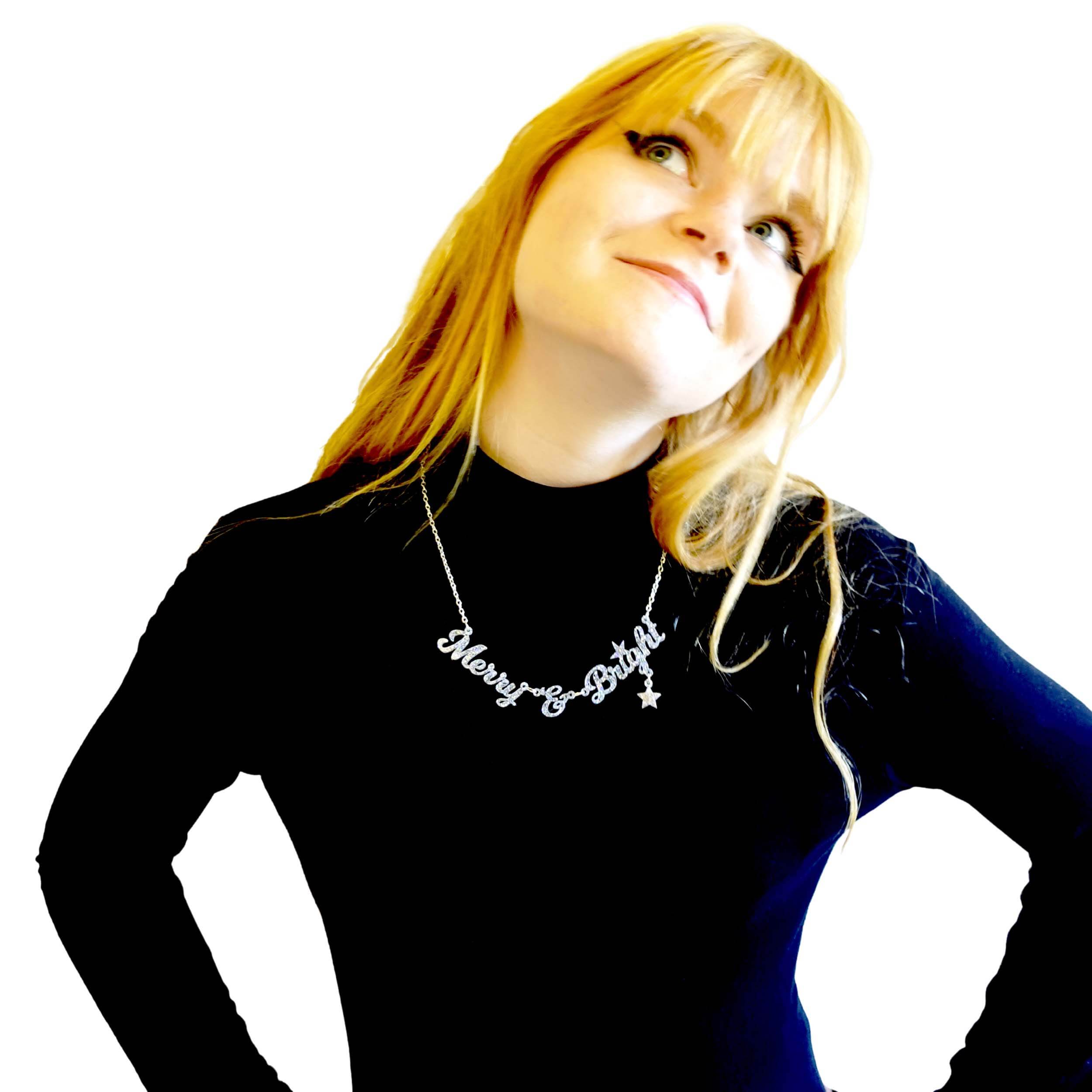 Eliza wears a silver glitter Merry & Bright necklace, part of the Christmas Collection at Wear and Resist.