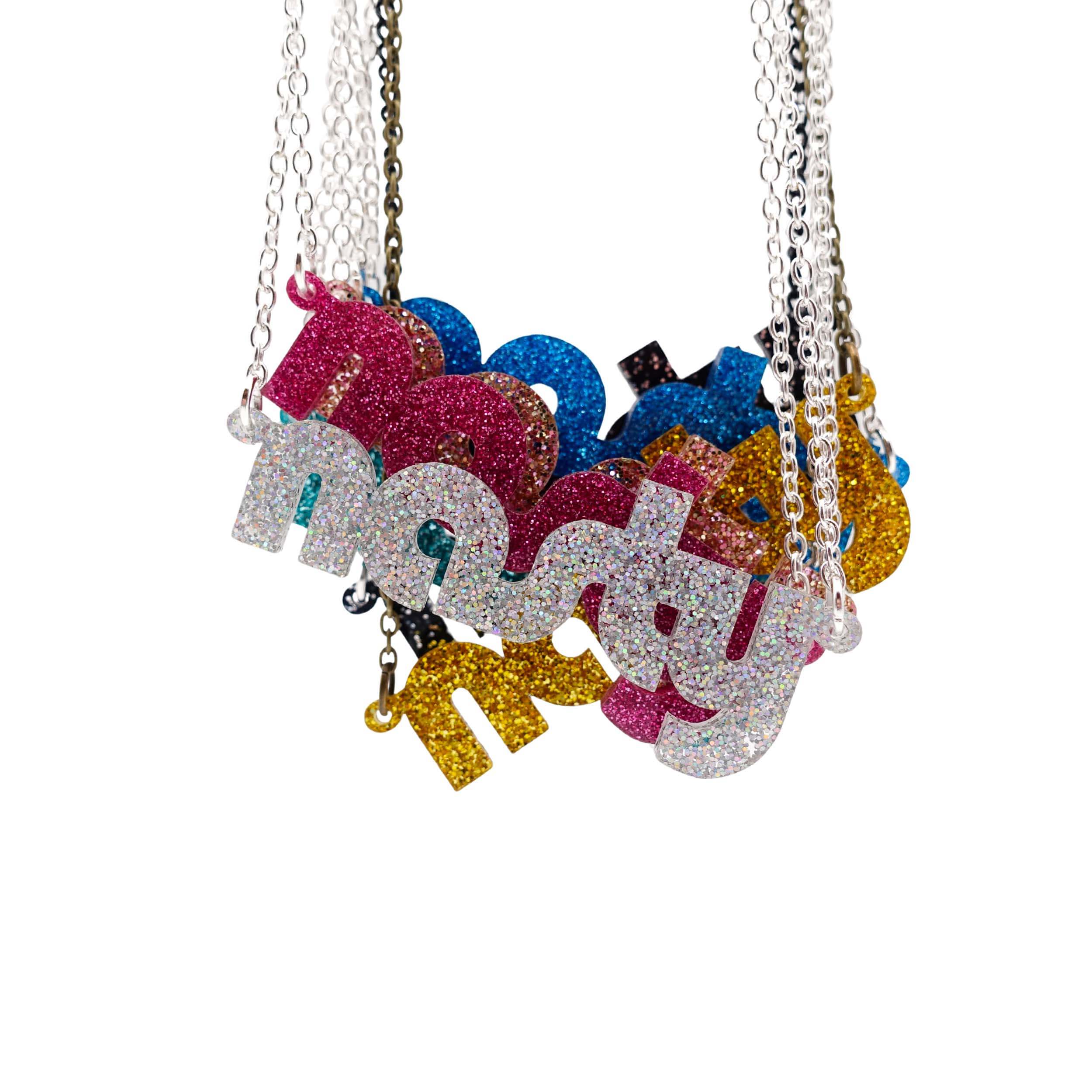 Nasty necklaces in glitter colours shown hanging together.