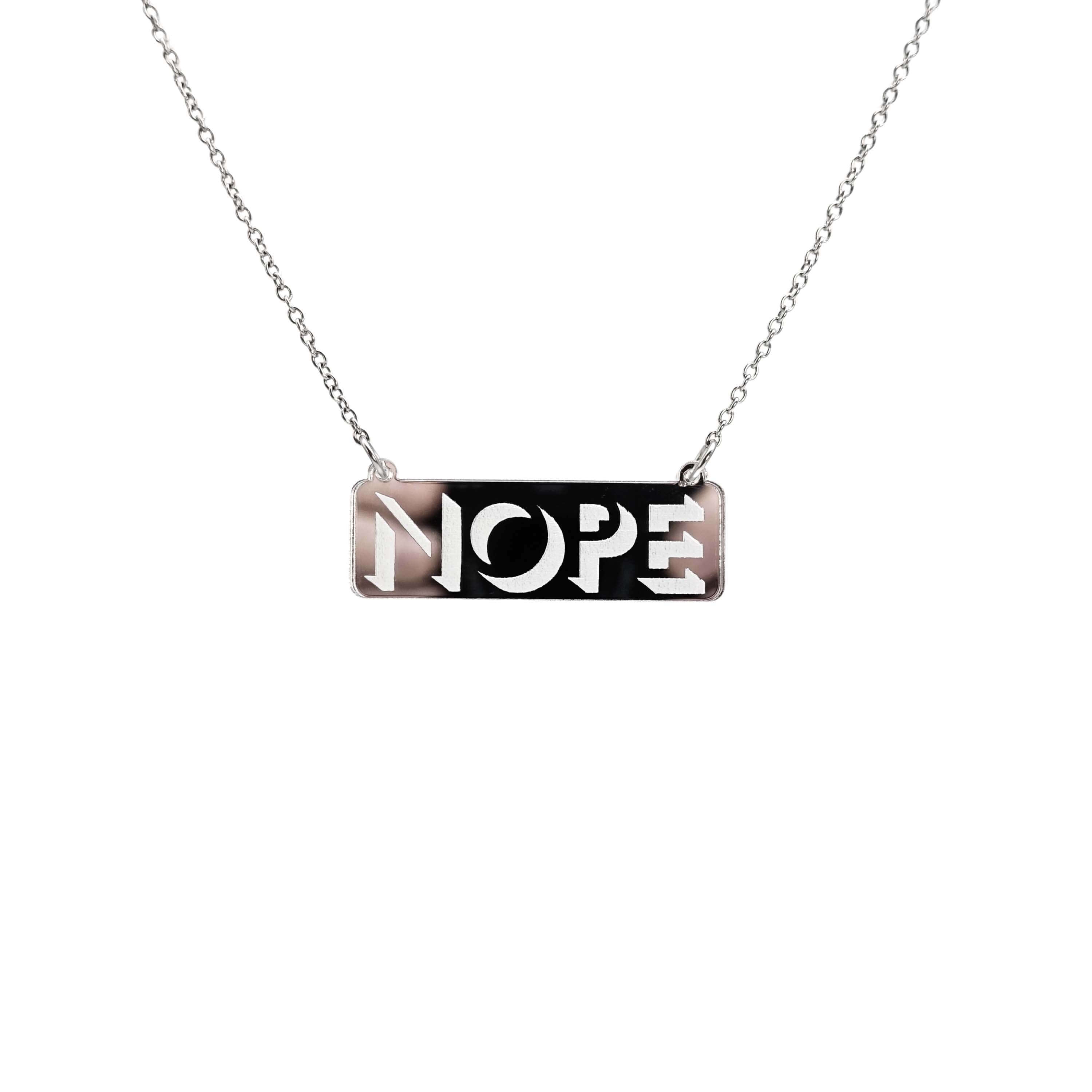 Nope necklace in silver mirror on a stainless steel chain hanging against a white background.