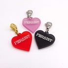 Heart charms in chilli frost, pink frost and slate frost etched in glow-in-the-dark pigment with the word 'Persist'