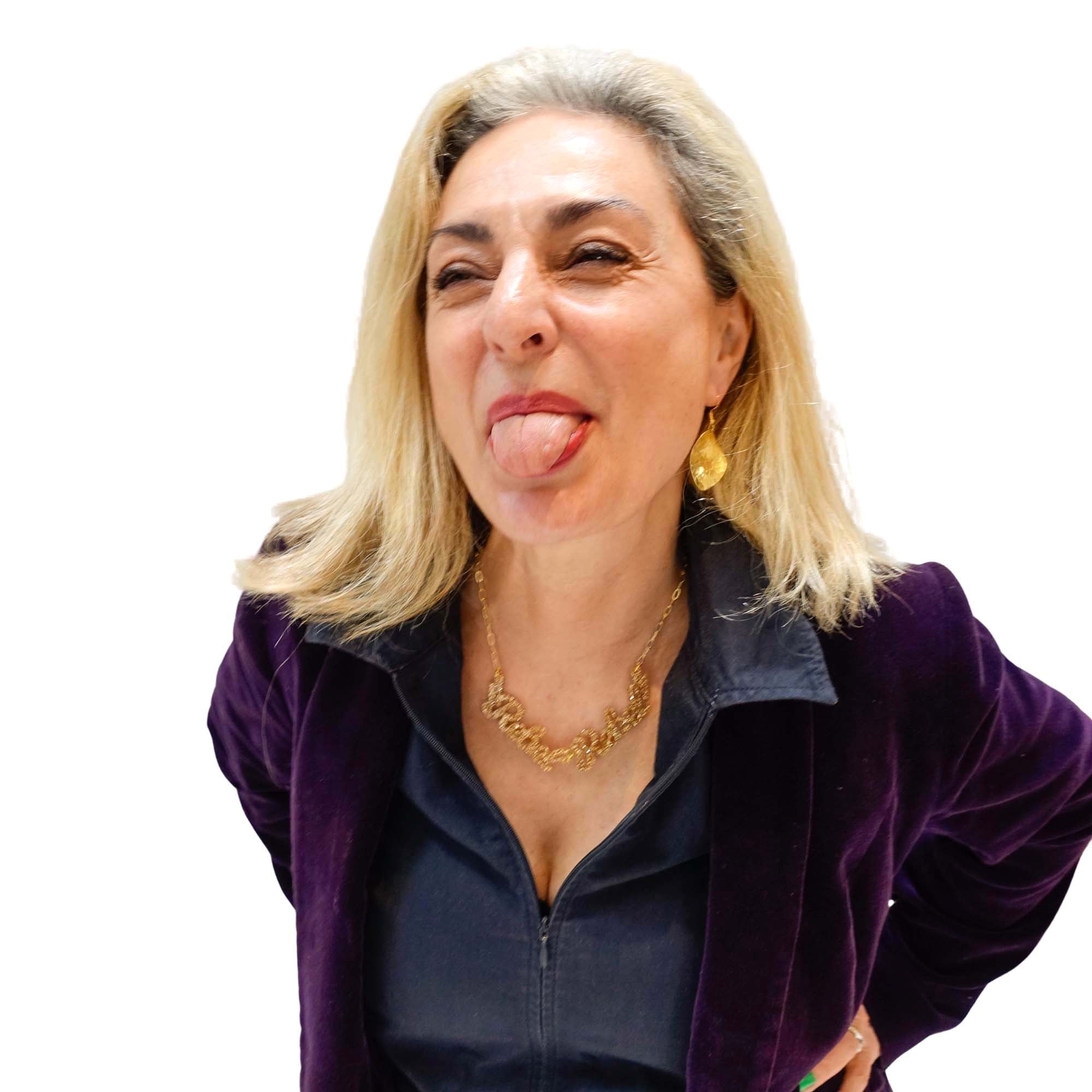 Andrea sticks out her tongue wearing a gold glitter Rebel Rebel necklace.