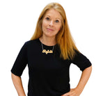 Sarah Day, founder of Wear and Resist wears a matte iridescent Rejoin the EU necklace.