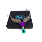 A winged heart necklace with the words 'Resist' and 'Persist' etched on it, on a Wear and Resist gift box.