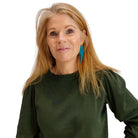 Sarah wears massive Lightning Bolt hoop earrings in teal mirror.