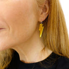 Sarah wears medium Lightning Bolt earrings in yellow mirror on silver hoops.