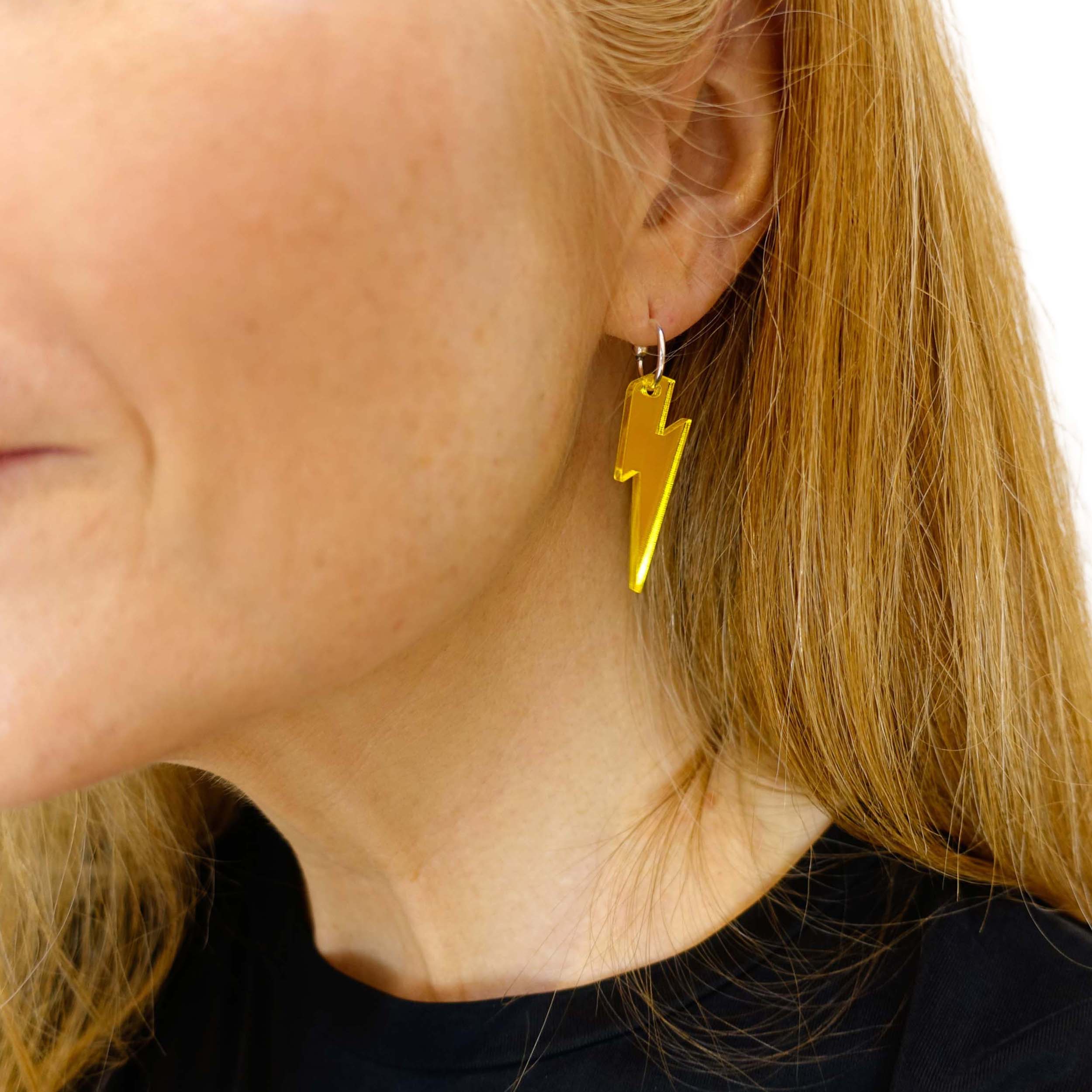 Sarah wears medium Lightning Bolt earrings in yellow mirror on silver hoops.