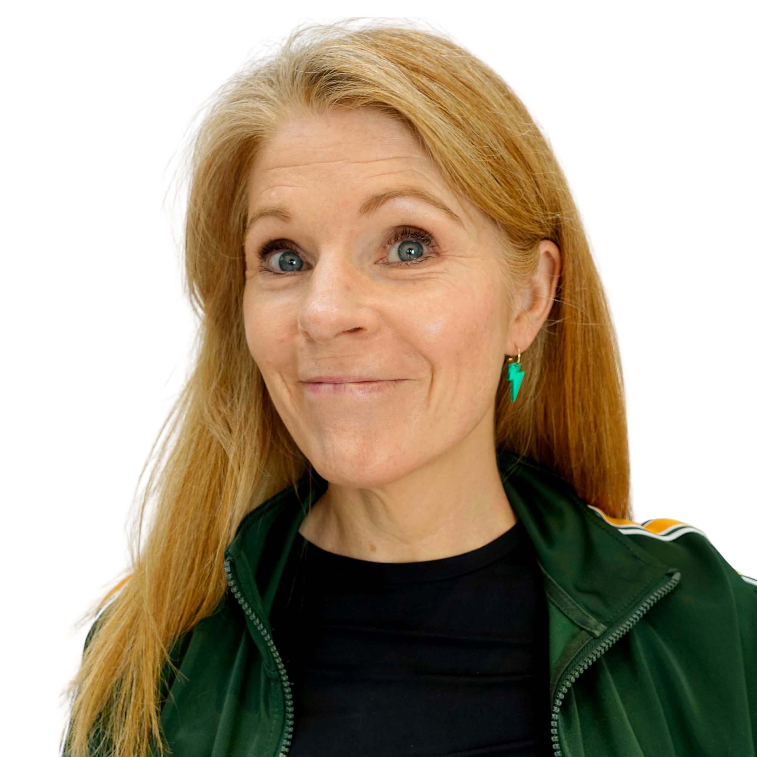 Sarah wears small electric green mirror lightning bolt hoop earrings.