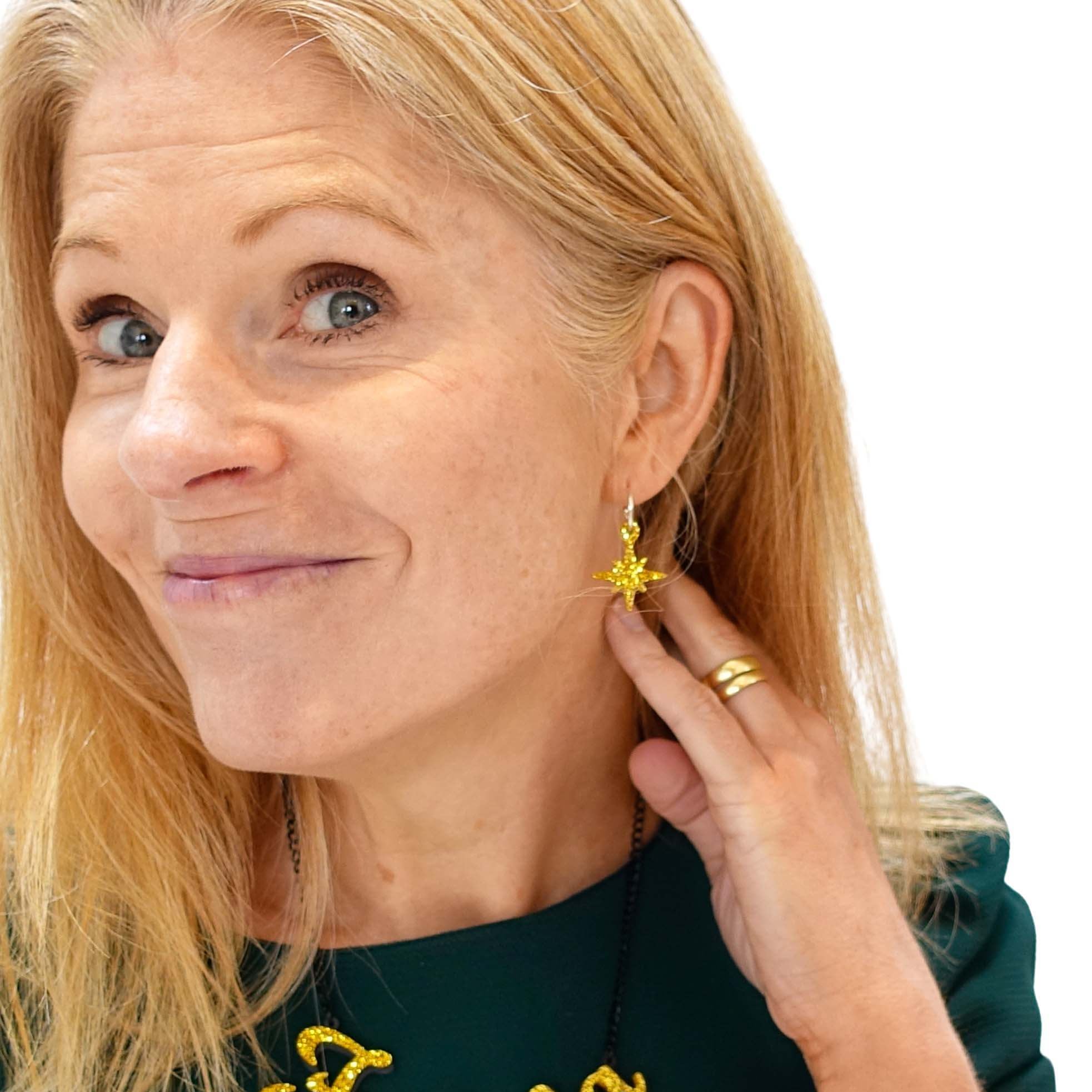 Sarah wears ultra gold glitter limited edition Festive Vintage Star earrings, with a matching Fa La La necklace.
