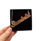Steminist necklace for women working in STEM in matte iridescent shown held up in a Wear and Resist gift box.