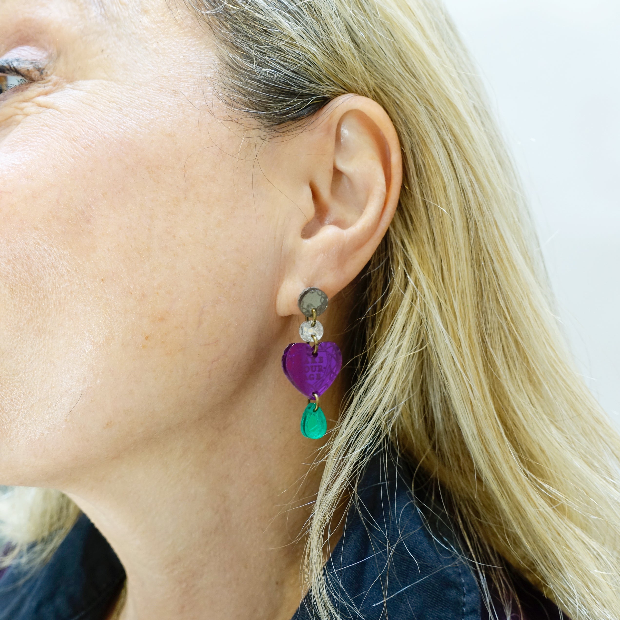 Andrea wears the Take Courage purple heart drop earrings from the Suffragette collection.