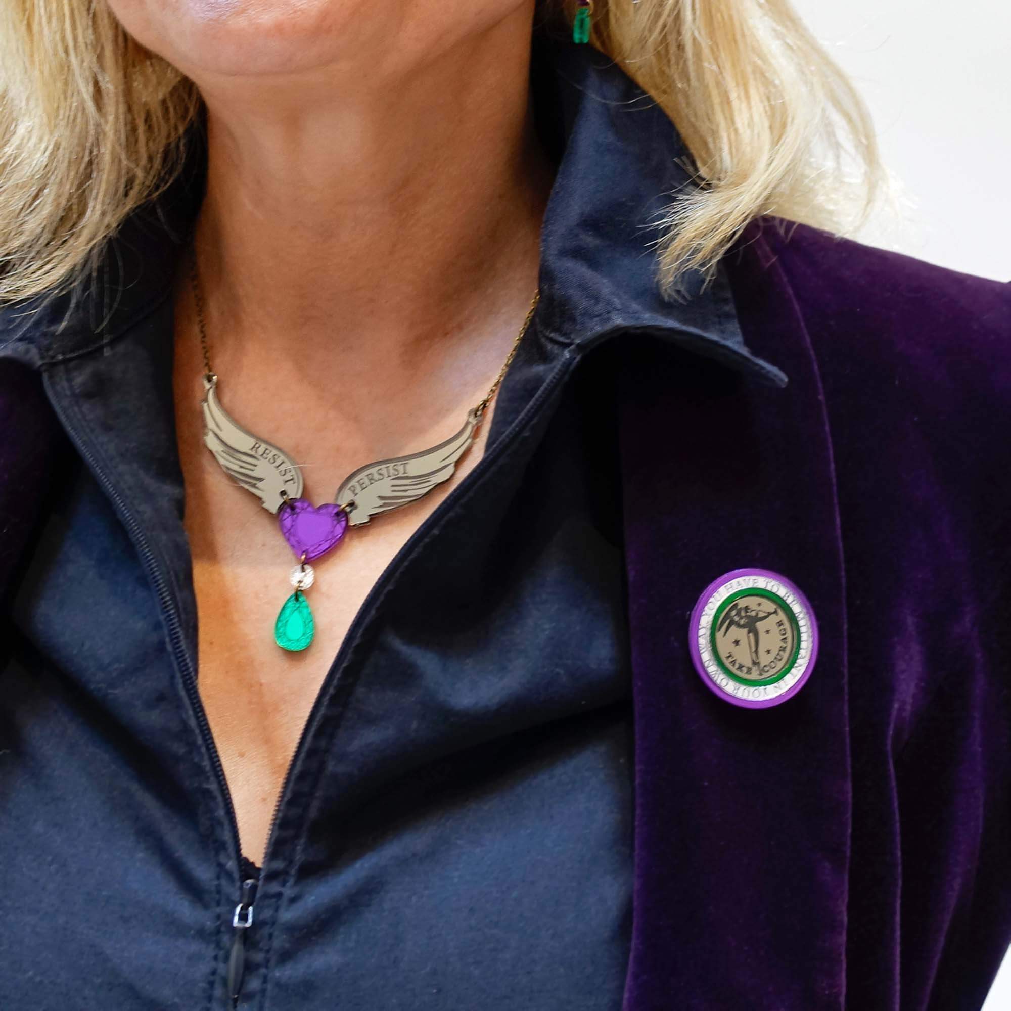 Andrea wears the brooch with a Resist Persist winged Heart necklace.