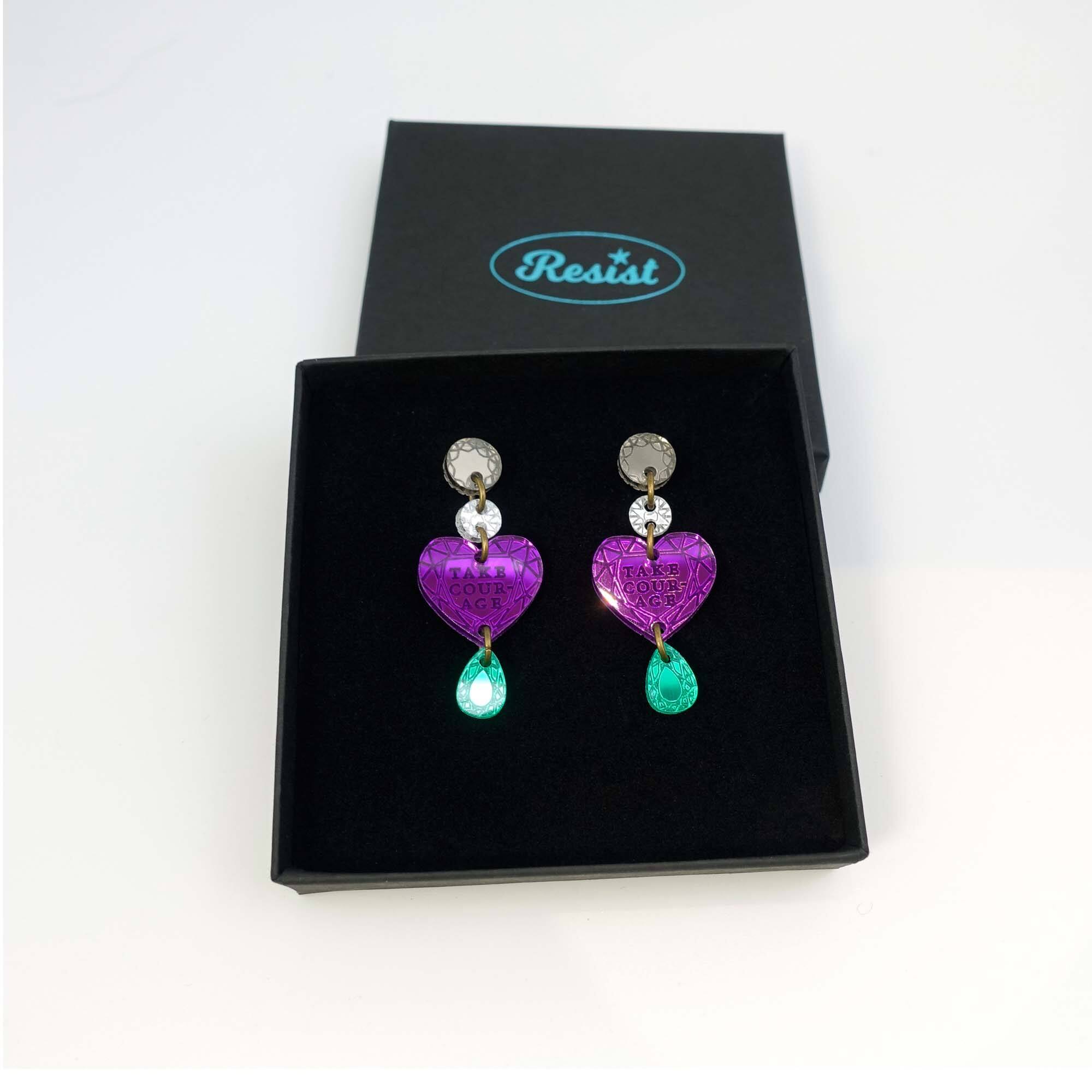 Purple heart drop earrings engraved with the words, Take Courage, in the suffragette colours. Shown in a Wear and Resist gift box.