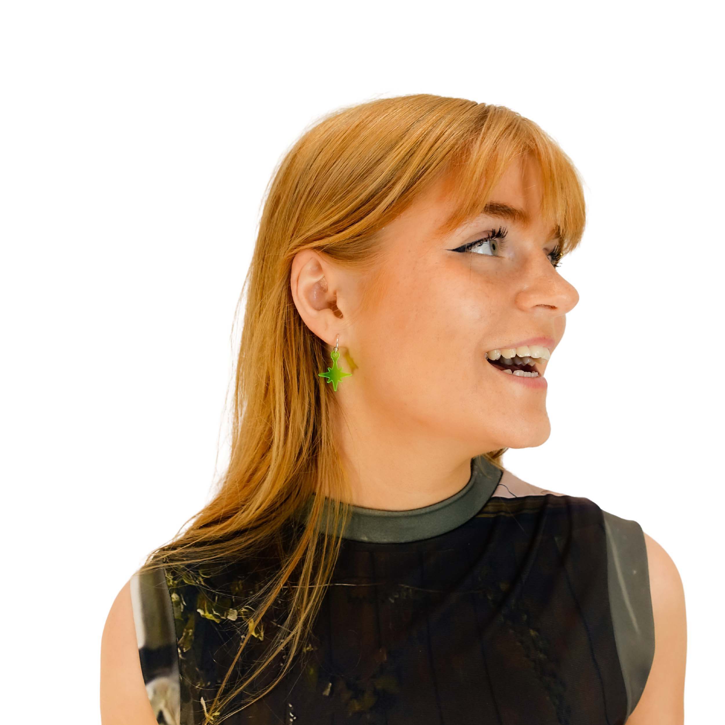 Eliza wears neon green vintage star hoop earrings.