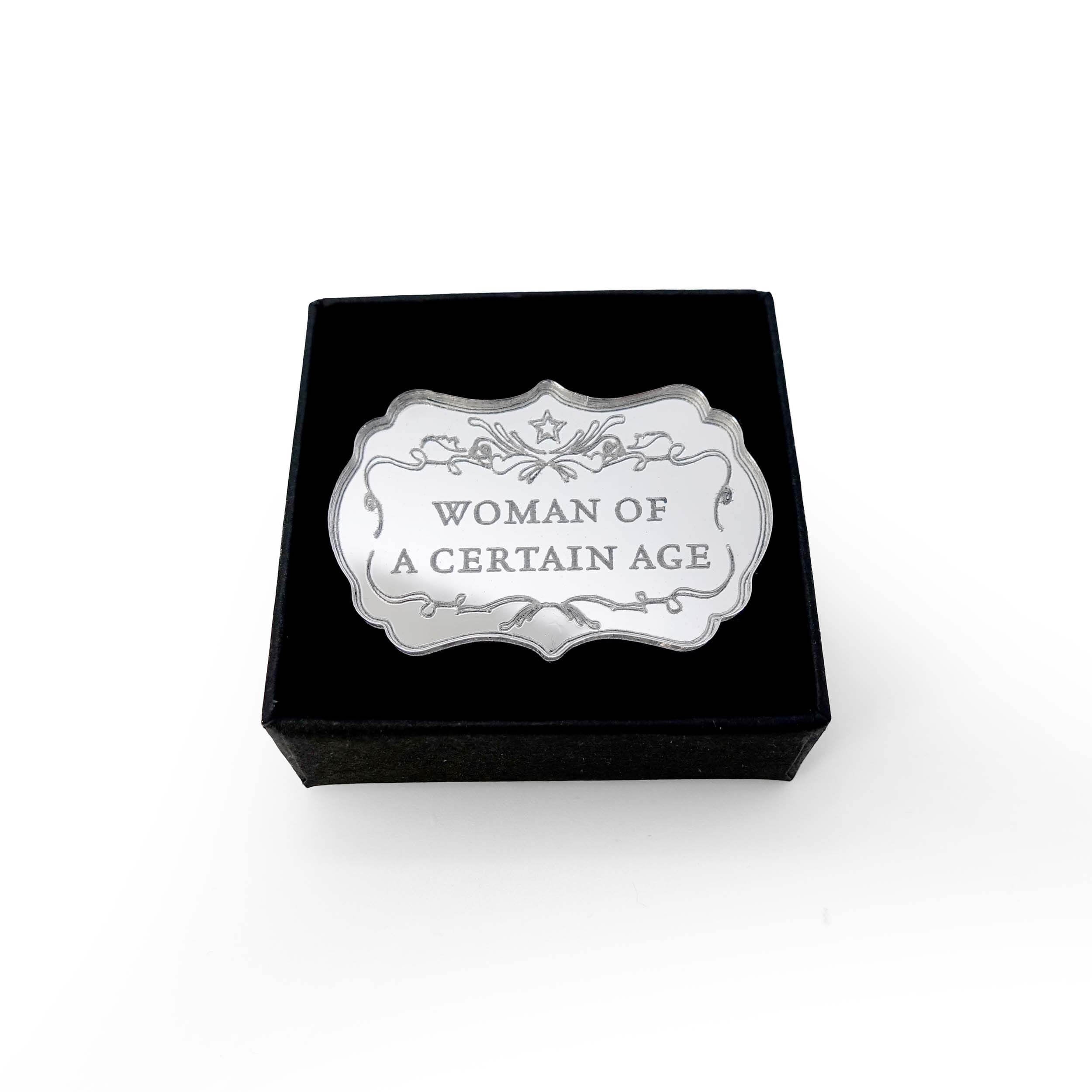 Woman of a Certain Age brooch shown in a Wear and Resist gift box.