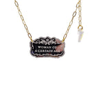 Silver etched Woman of a Certain Age necklace shown hanging on a gold paperclip chain with an iridescent lightning bolt.