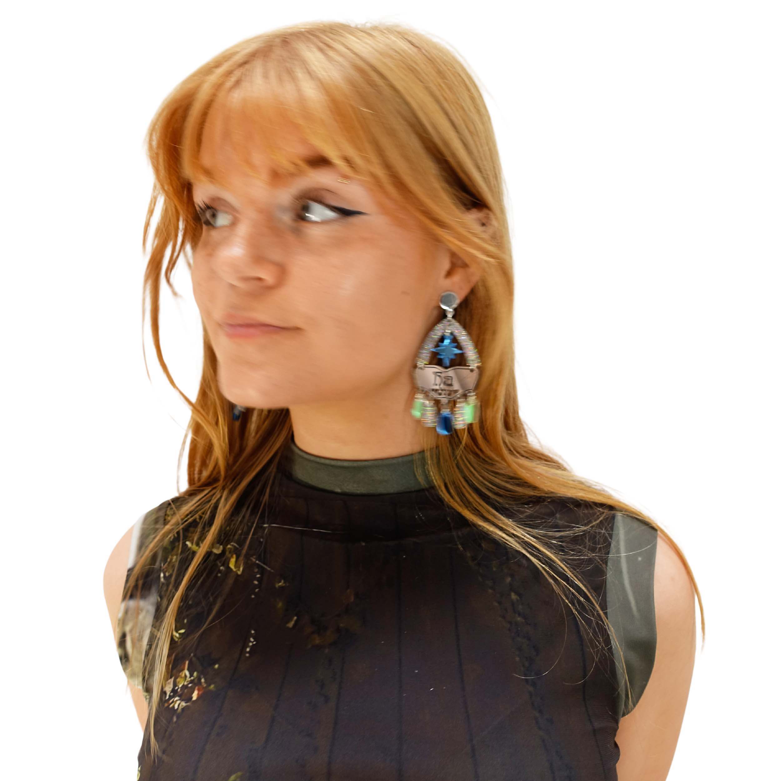 Eliza wears the Sky Cowgirl colourway of the Western style statement earrings with the words Yee Ha engraved on them.