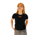 Eliza wears an orange Yee-Ha necklace.