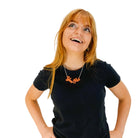 Eliza wears an orange Yee Ha necklace.