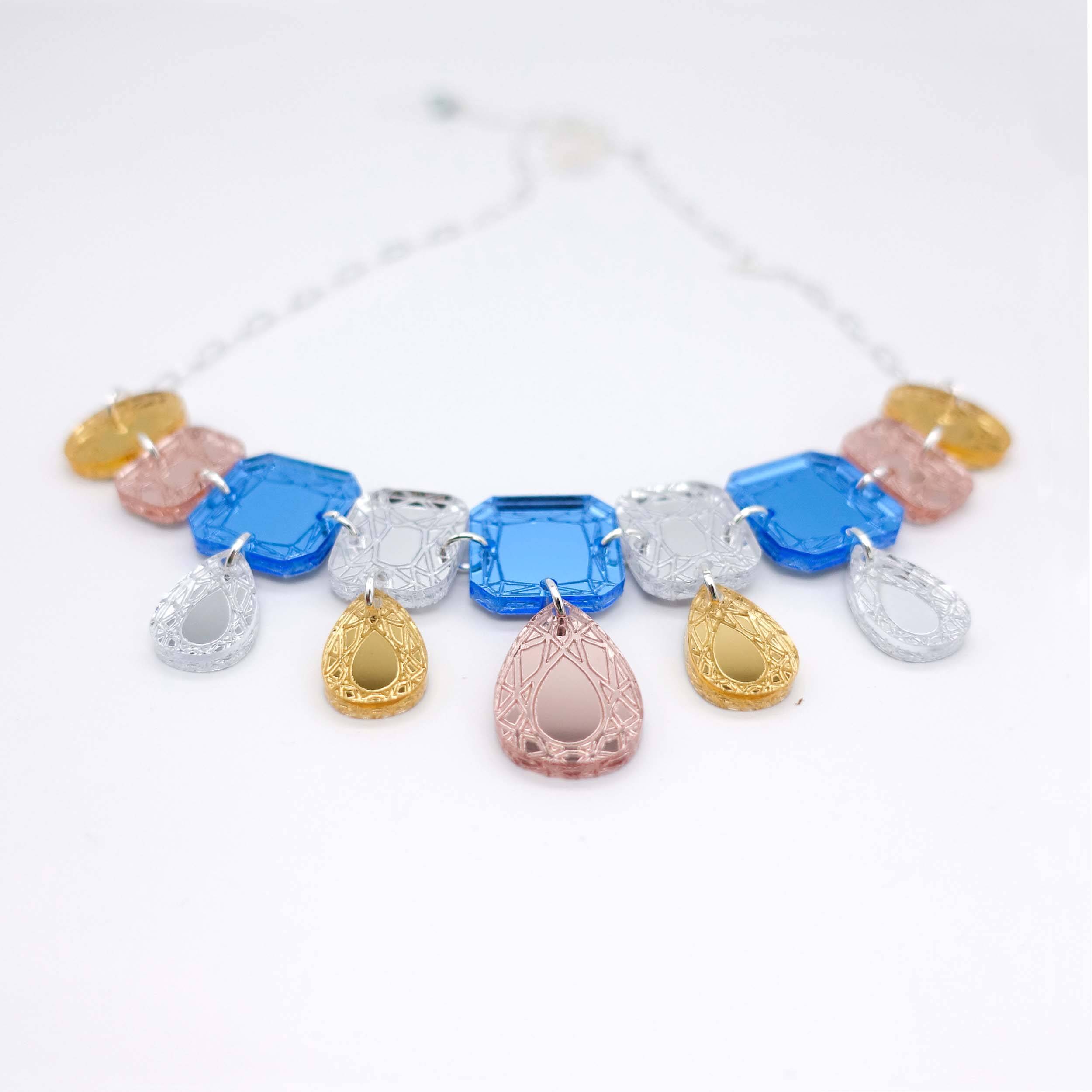 Belle Epoque jewe necklace in soft blue colours, shown on a white background. Designed by Sarah Day for Wear and Resist. £2 goes to Women for Refugee Women.