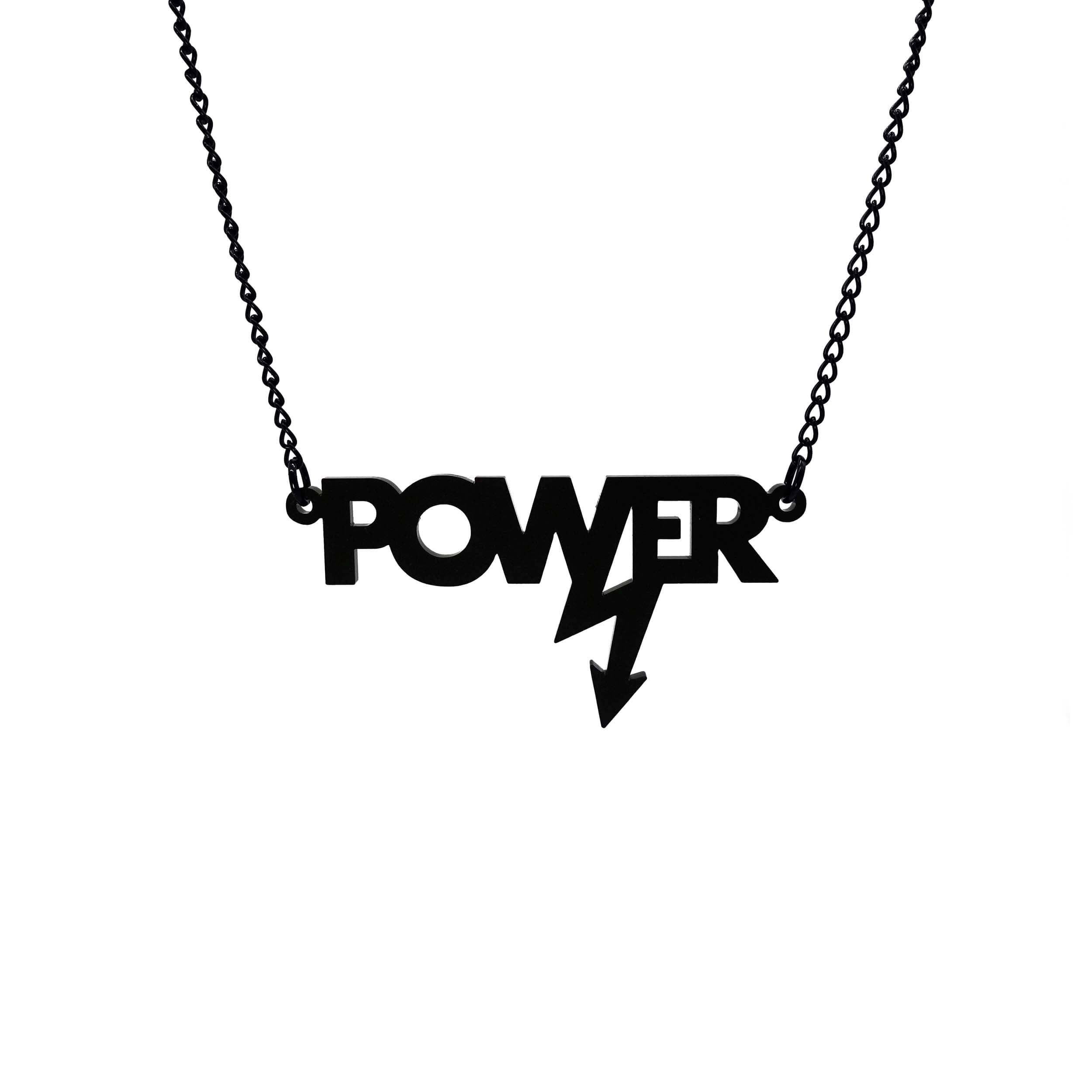 Mini power necklace in matte black shown hanging on a black chain against a white background. Designed in collaboration with Mary Beard for her book Women and Power.