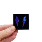 Medium Lightning Bolt earrings in electric blue mirror, shown held up in a small Wear and Resist gift box.