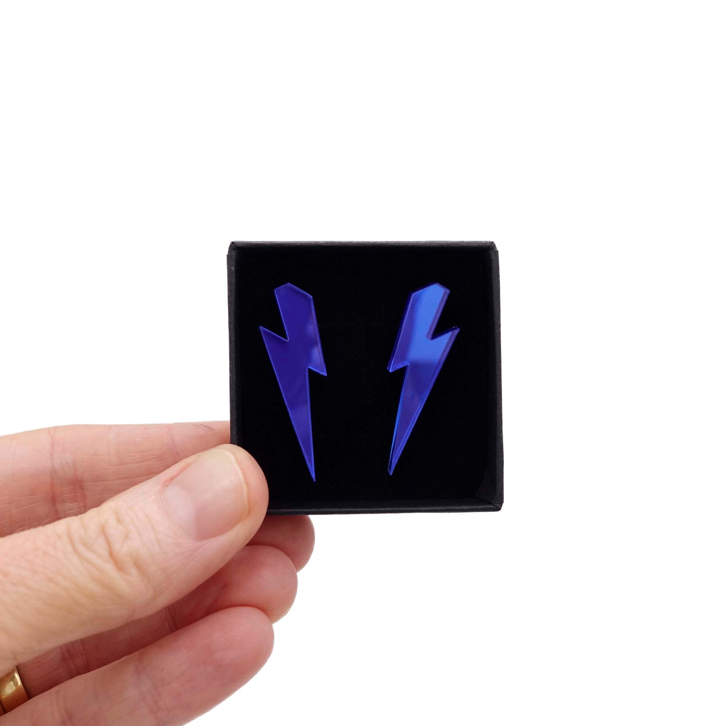 Medium Lightning Bolt earrings in electric blue mirror, shown held up in a small Wear and Resist gift box.