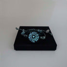 The No Coward Soul is Mine bracelet glowing in the dark on a Wear and Resist gift box. From the Brontë Collection.