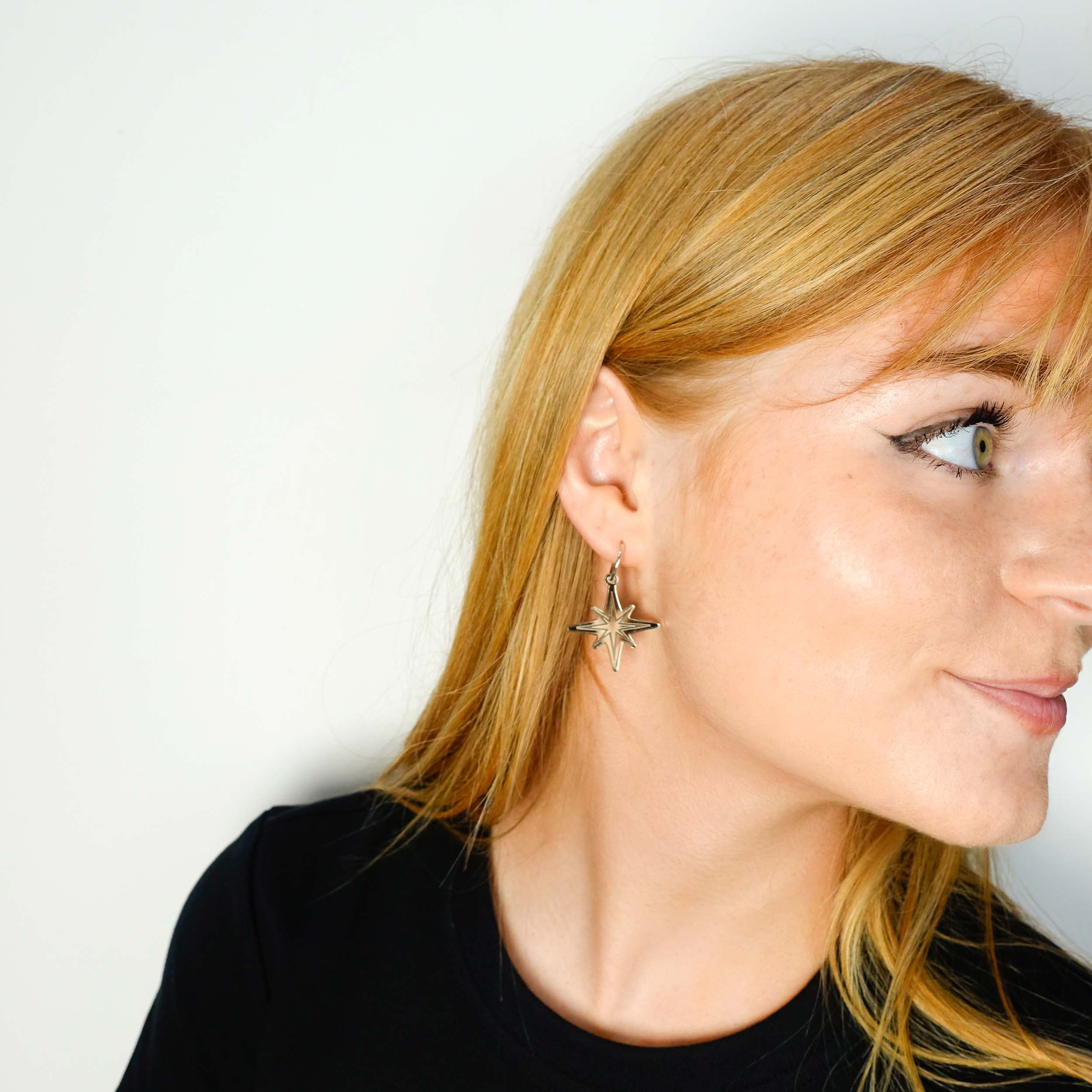 Eliza wears bronze mirror etched Vintage Star earrings, part of the Bronte Collection.