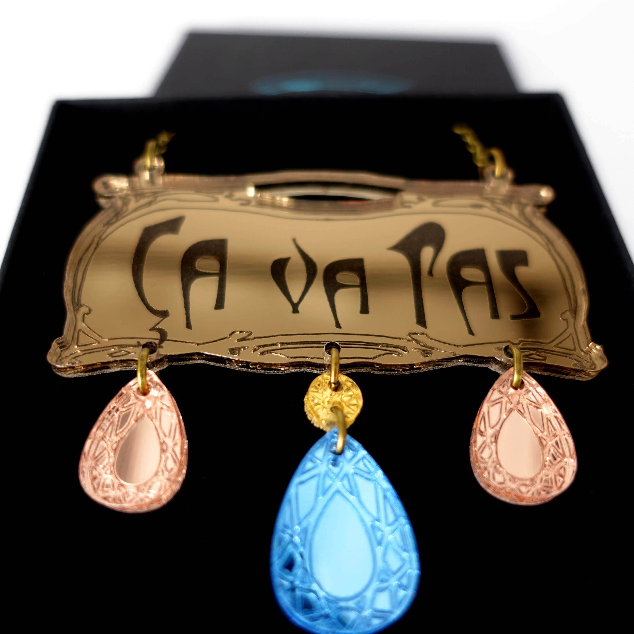 A close up of the Belle Epoque inspired CA VA PAS necklace with rose gold and sky drops.  Part of the Paris Collection, designed by Sarah Day for Wear and Resist. Jewellery for Francophiles!