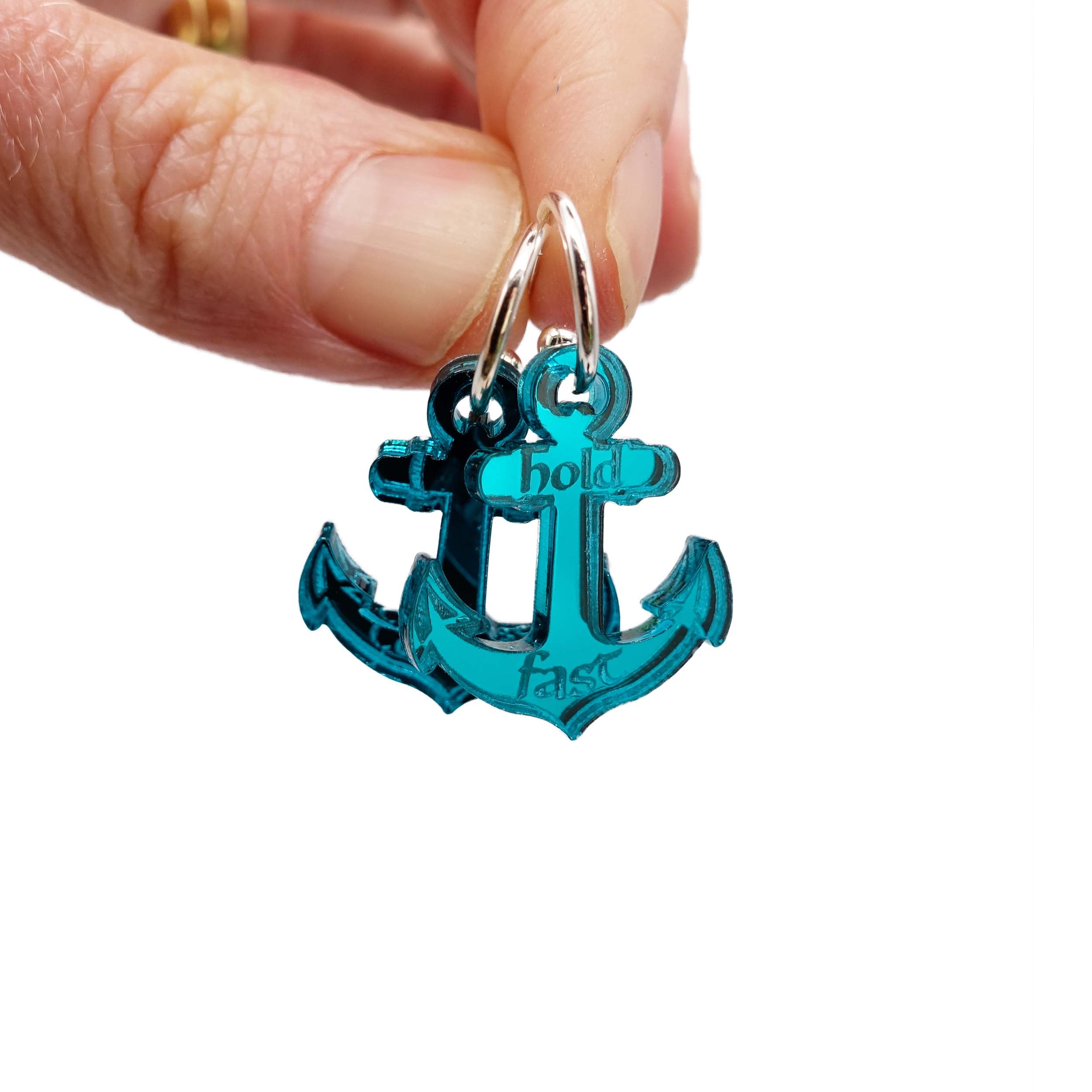 Medium anchor earrings etched with the words 'courage' on one and 'hold fast' on the other. Shown here held up in my hand for scale. They come on silver or gold plated hoops.