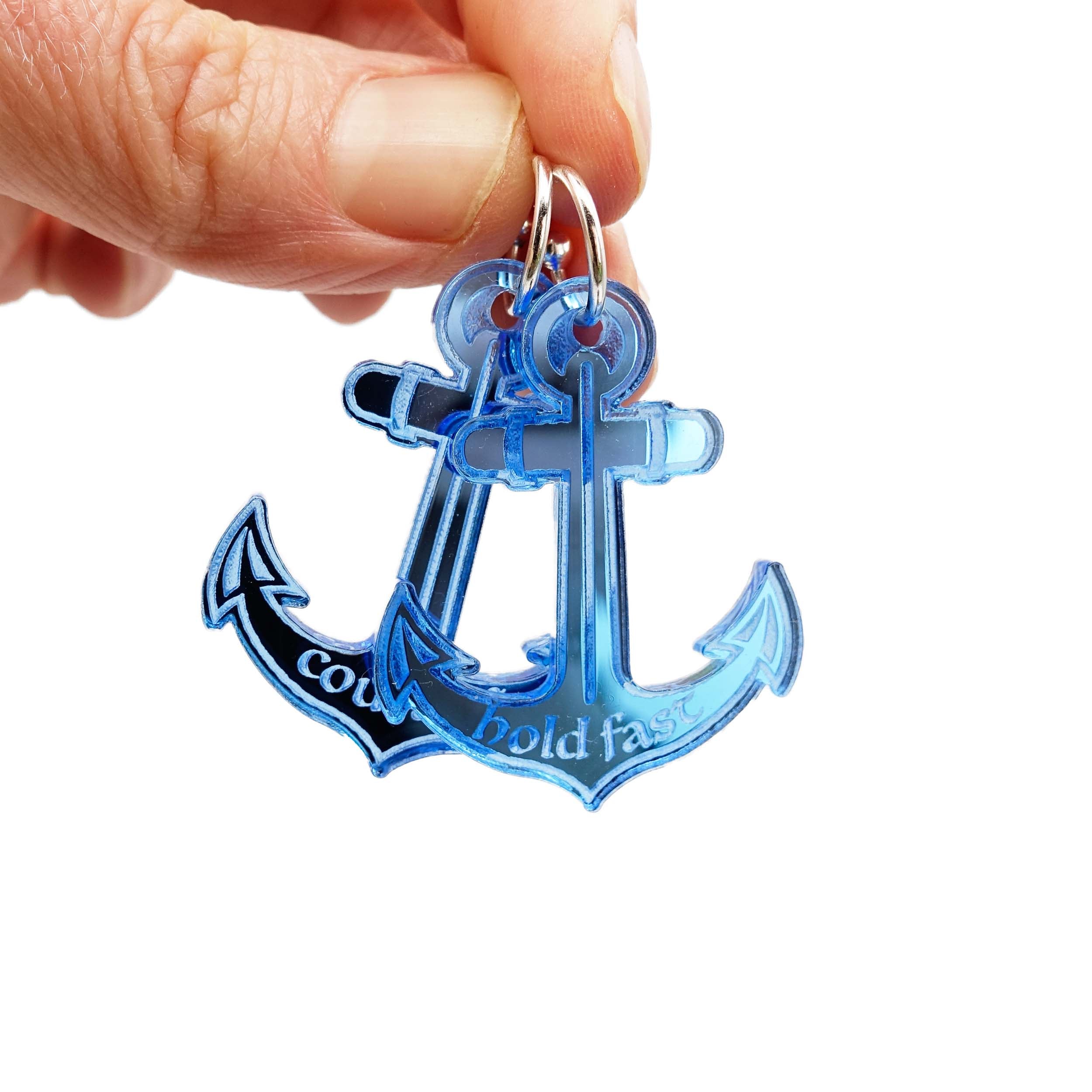 Courage and Hold Fast anchor earrings from the Courage Collection, shown held up for size against a white background.