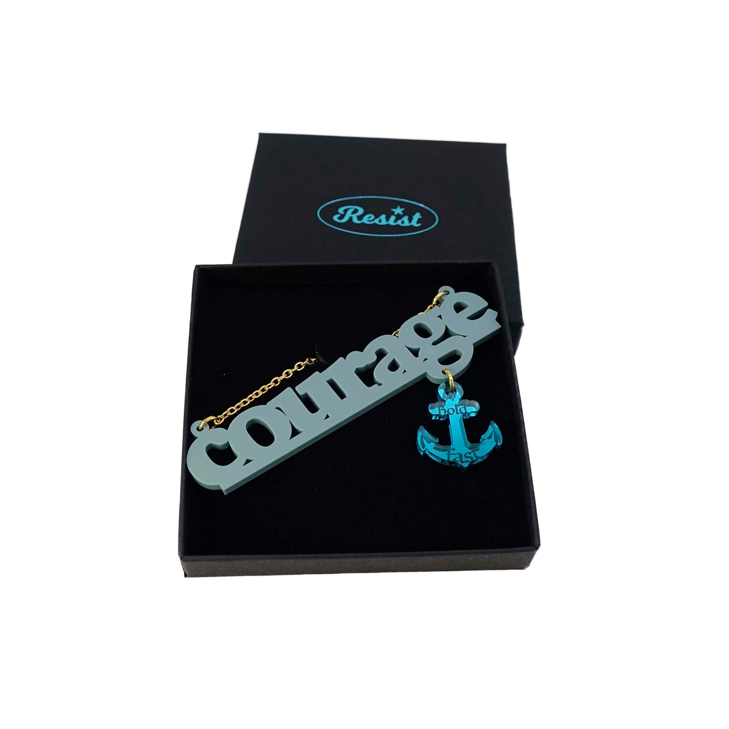 Courage necklace in duck egg green with teal dangling anchor etched with the words, 'hold fast,' shown on a Wear and Resist gift box.