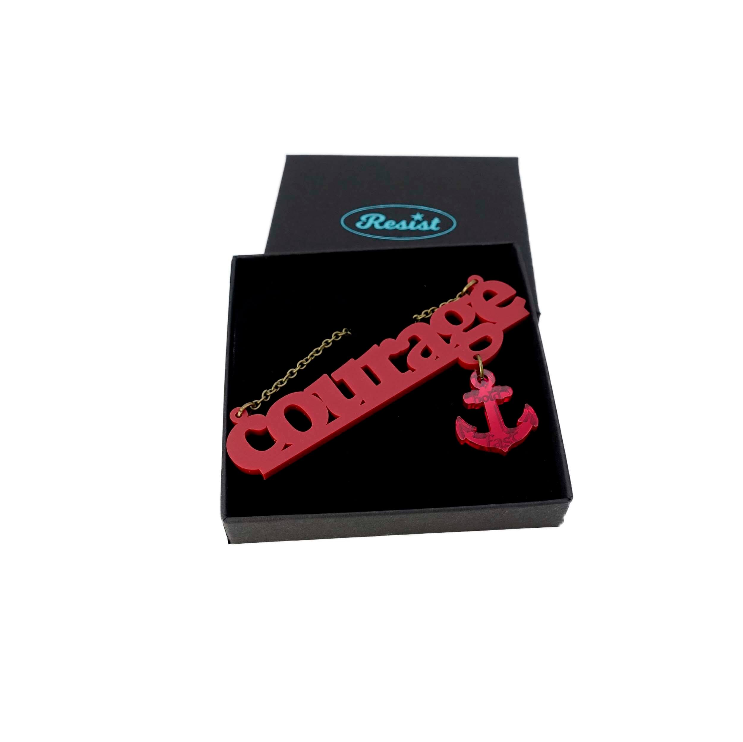 Courage necklace in carmine red with ruby dangling anchor etched with the words, 'hold fast,' shown on a Wear and Resist gift box.