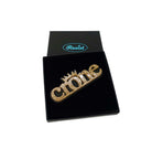 Owning the Crone! A Crone brooch in gold glitter shown in a Wear and Resist gift box.