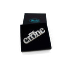 Crone brooch in silver glitter shown in a Wear and Resist gift box.