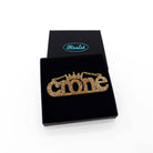 Crone necklace in gold glitter, shown in a Wear and Resist gift box.