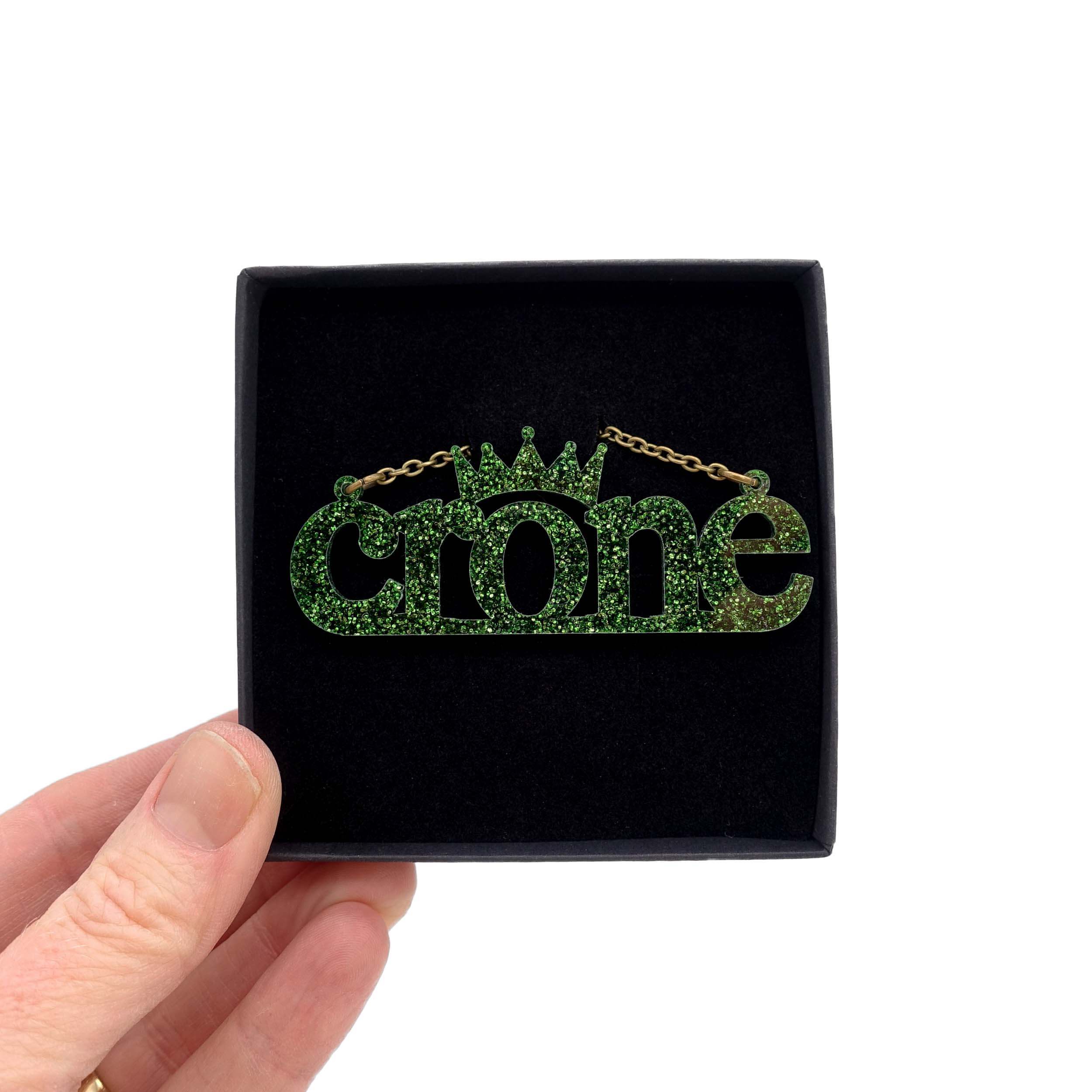 Crone necklace in moss glitter, shown in a Wear and Resist gift box.