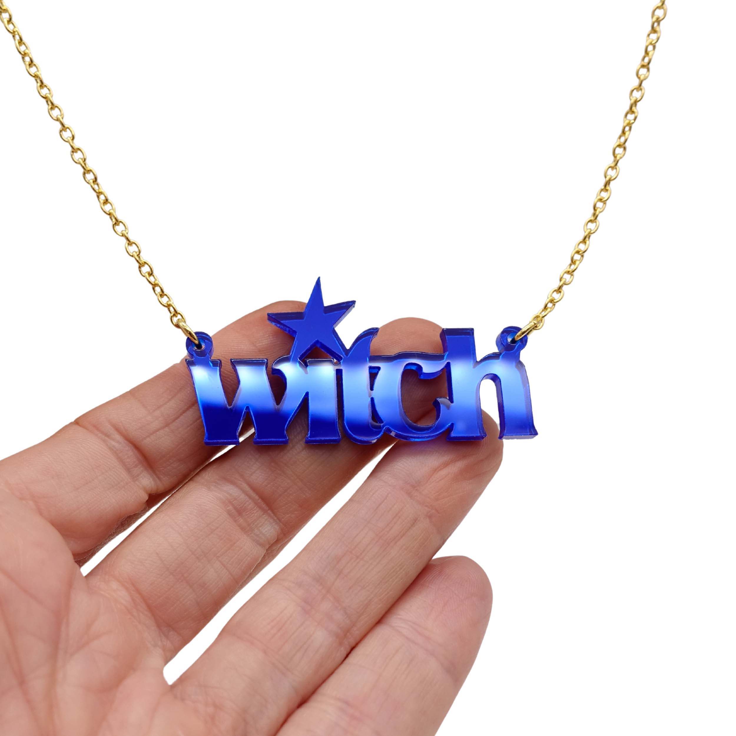 Witch necklace in electric blue mirror shown hanging against a white background with my hand for size.