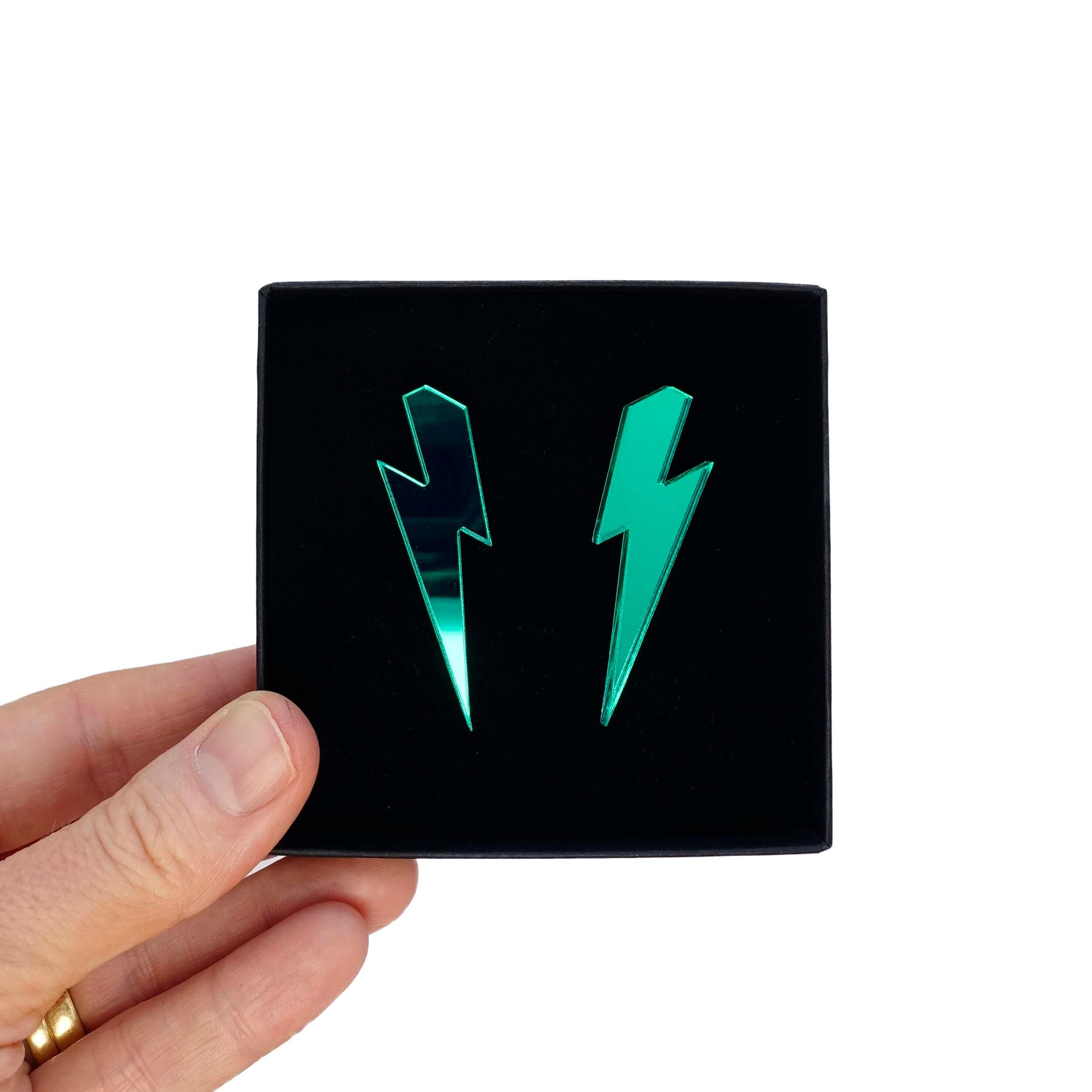 Large Lightning Bolt earrings in electric green mirror, shown held up in a Wear and Resist gift box.