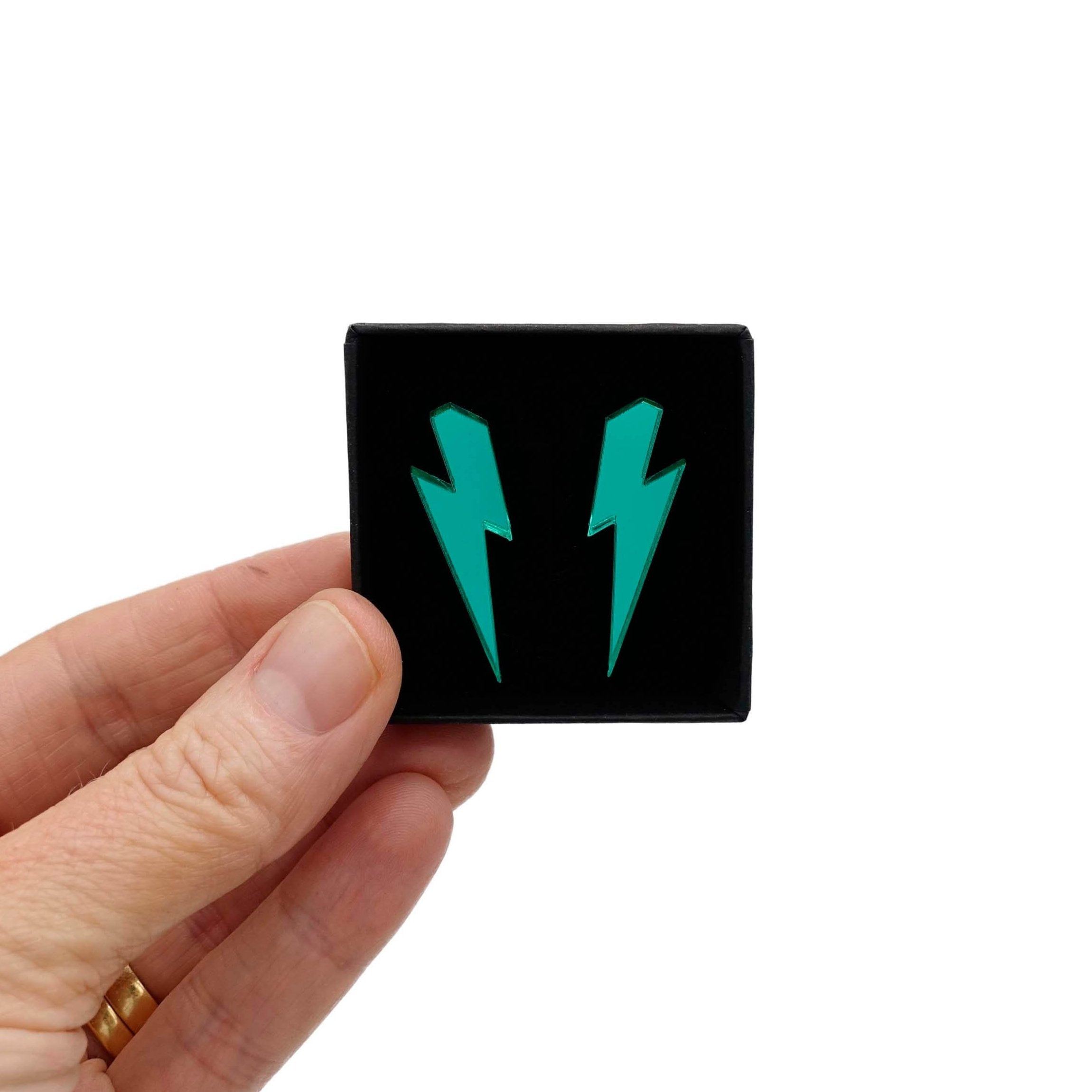 Medium Lightning Bolt earrings in electric green mirror, shown held up in a small Wear and Resist gift box.