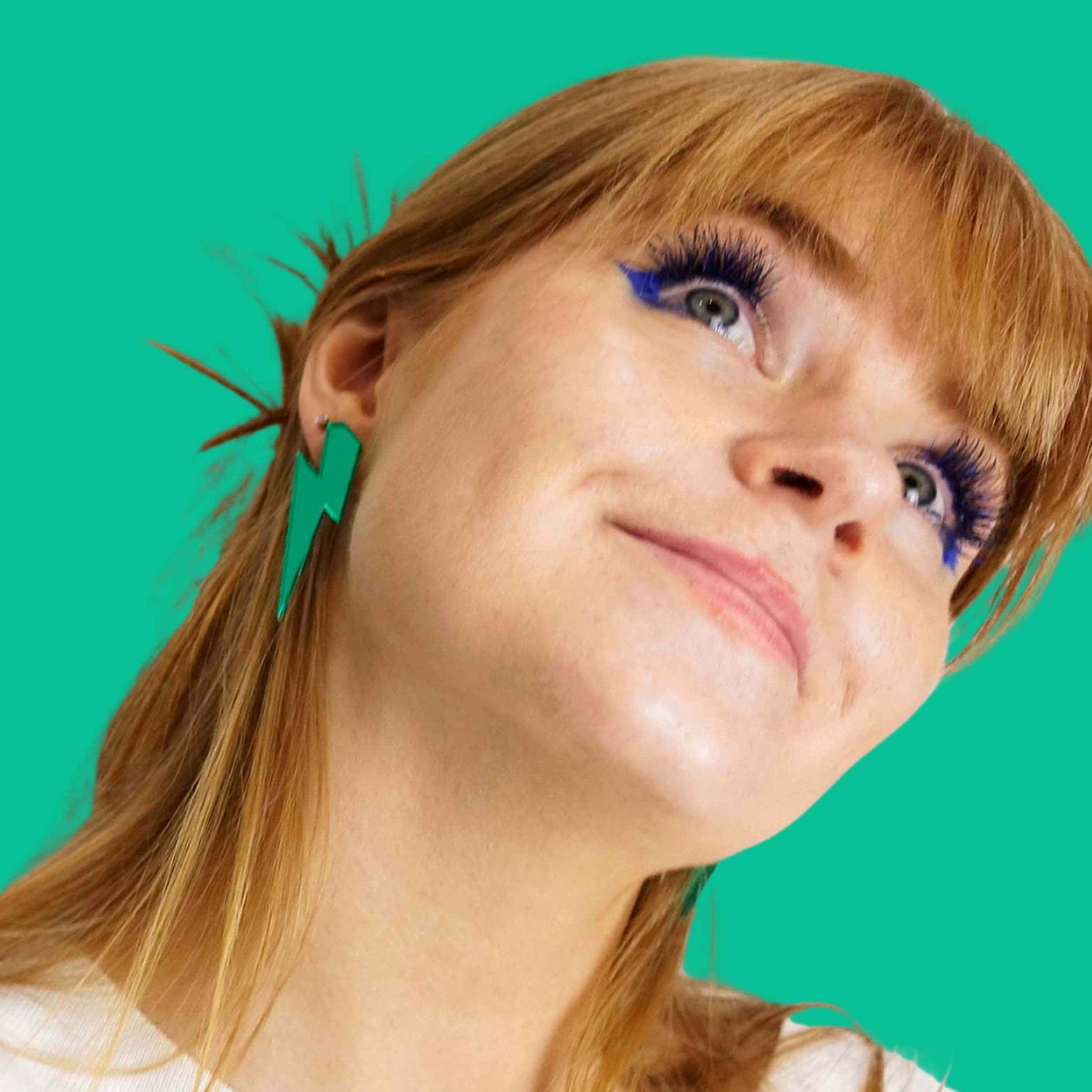 Eliza wears large Lightning Bolt earrings in electric green.